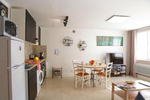 kuchnia i jadalnia ze stołem i lodówką w obiekcie Superbe appartement tout confort "Le Séquoia" w mieście Monchy-Saint-Éloi