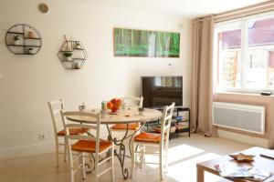 een eetkamer met een tafel en stoelen bij Superbe appartement tout confort "Le Séquoia" in Monchy-Saint-Éloi