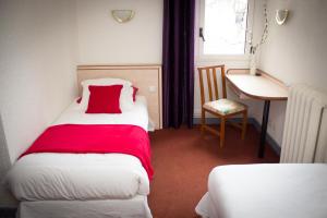 ein kleines Zimmer mit einem Bett mit einer roten Decke in der Unterkunft Le Terminus in Tarascon