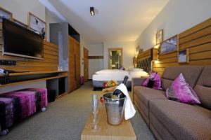 a hotel room with a couch and a bed at Hotel Vista Allegra in Ischgl