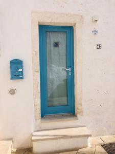 a blue door on the side of a building at Dimore del TEMPO PERS0 Mare videre in Ostuni