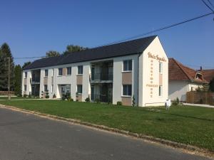 a large white building on the side of a street at Főnix Apartman in Lenti