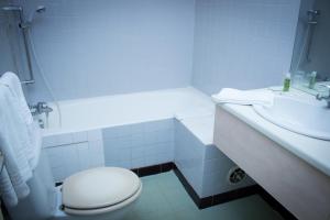 ein weißes Bad mit einem WC und einem Waschbecken in der Unterkunft Le Terminus in Tarascon