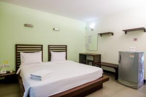1 dormitorio con 1 cama grande con sábanas blancas en S Hotel Kanchanaburi, en Kanchanaburi