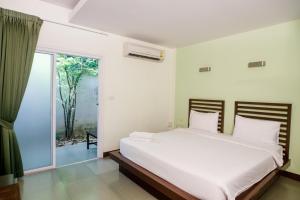 a bedroom with a large white bed and a window at S Hotel Kanchanaburi in Kanchanaburi City