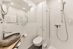 W łazience znajduje się umywalka, toaleta i prysznic. w obiekcie Arens Hotel 327mNN w mieście Sankt Martin