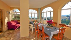 a dining room with a table and chairs and windows at Villa Antonia in Mataró