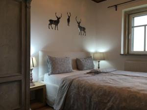a bedroom with a bed with deer heads on the wall at K Zastavce 557 in Kovářská