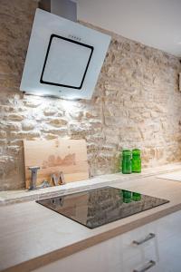 een keuken met een wastafel en een tv aan de muur bij Petit Montrachet in Chassagne-Montrachet