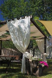 tenda con tavolo e fiori in cortile di La Petrusa a Vernole