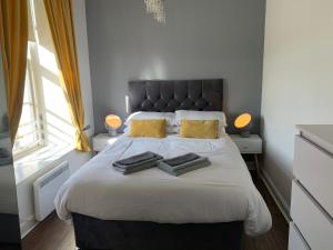 een slaapkamer met een groot bed en 2 handdoeken bij Ayr Apartment with Sea and Countryside views in Ayr