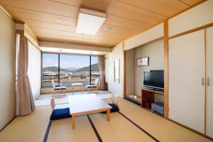 een woonkamer met een tafel en een televisie bij Hotel Park in Gifu