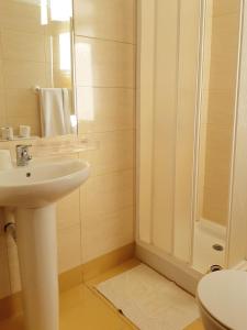 a white bathroom with a sink and a shower at Residencial Do Vale in Funchal