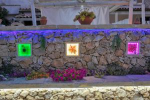 una pared de piedra con luces de colores. en Residence Villa Grotta Monaca, en Otranto