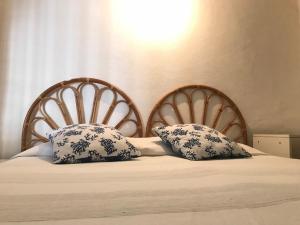 ポンツァにあるCupido - Immobilevanteのベッド1台(木製ヘッドボード2つ、枕2つ付)