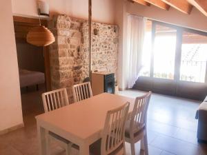 ein Esszimmer mit einem Tisch, Stühlen und einem Fenster in der Unterkunft Apartamentos Casa Les Valeres in Fuentespalda