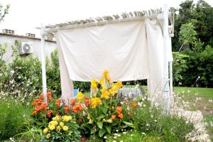 un jardín con una cortina blanca y flores en Residence Villa Grotta Monaca, en Otranto