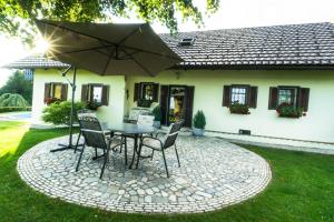 a patio with a table and chairs and an umbrella at Holiday House in Nature with Pool, Pr Matažič in Kamnik