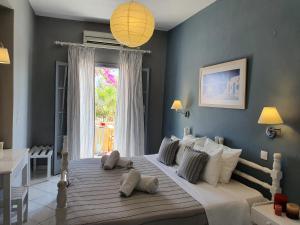 1 dormitorio con 1 cama blanca grande y ventana en Nostos Beach en Kamari