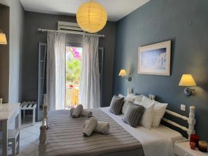 a bedroom with a large white bed with a window at Nostos Beach in Kamari