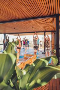 um grupo de pessoas fazendo yoga em um deck em Moana Eco Surf House em Sopelana