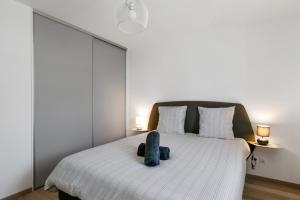 um quarto com uma cama com um bicho de peluche em Spacious 1-bedroom with terrace 15 min from Lake Annecy Welkeys em Annecy