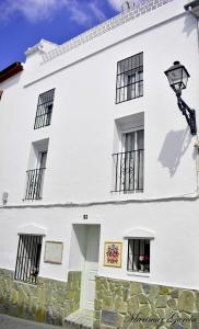 - un bâtiment blanc avec des fenêtres noires et une lumière de rue dans l'établissement Caracuel de Badía, à El Burgo