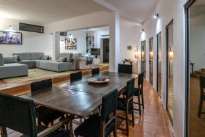 comedor y sala de estar con mesa de madera y sillas en Made iN2 Creative Guest House, en Montargil