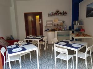 a dining room with tables and chairs and a kitchen at B&B Trapani Mare in Trapani