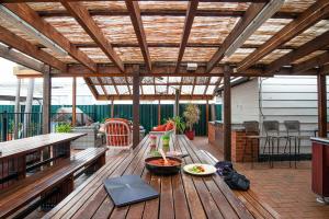 a wooden deck with a table with food on it at Backpackers Newcastle in Newcastle