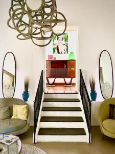 sala de estar con escalera y lámpara de araña en Melodia3 Suites Noto, en Noto