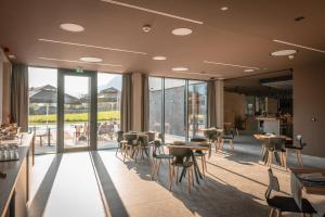 a restaurant with tables and chairs and windows at Hotel Soča in Bovec