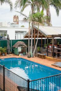 a swimming pool with a fence around it at Backpackers Newcastle in Newcastle