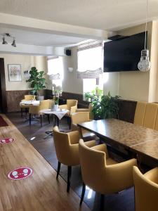 a dining room with tables and yellow chairs at Hotel & Restaurant Arnoldusklause in Düren - Eifel