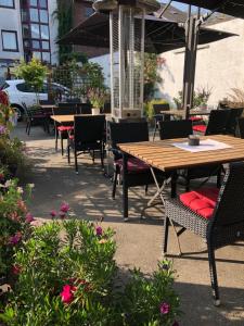 デューレン・アイフェルにあるHotel & Restaurant Arnoldusklauseの屋外パティオ(テーブル、椅子、花付)