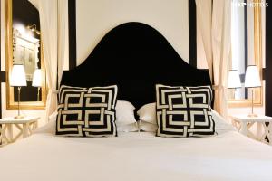 a bed with a black and white headboard and pillows at Cellai Hotel Florence in Florence