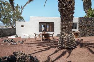 una casa con una mesa y una palmera en La Casita, en Famara