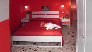 1 dormitorio rojo con 1 cama con pared roja en B&B Menen en Castellabate