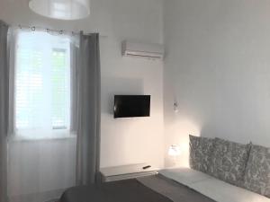 Camera bianca con letto e TV a parete di Franco-Home a Palermo