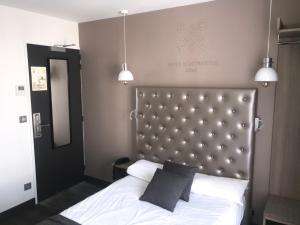 - une chambre avec un lit blanc et deux lampes suspendues dans l'établissement Hotel de Paris Montmartre, à Paris