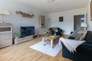 a living room with a couch and a tv at Ferienwohnungen Riese - Sonnenstrahl in Arnsberg