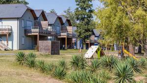 a playground in front of a house with a slide at Vacanceole - Relais du Plessis in Chaveignes