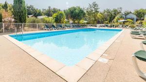 a large swimming pool with lounge chairs at Vacanceole - Relais du Plessis in Chaveignes