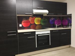 eine Küche mit schwarzen Schränken und bunten Schalen in der Unterkunft Hostel Airport in Oberglatt