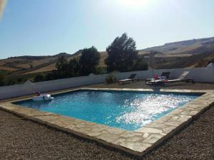 a swimming pool with a stone path around it at Beautiful Cortijo with pool near Ronda in Ronda