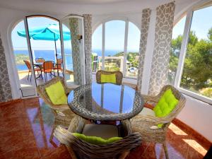 a dining room with a glass table and chairs at Casa Stefanie in Jávea