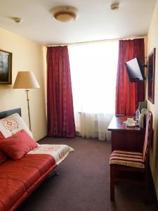 a hotel room with a bed and a desk and a window at AMAKS Azov Hotel in Azov