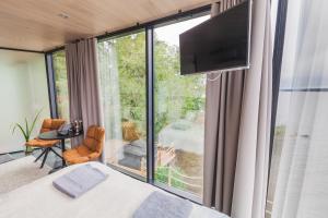 een slaapkamer met een bed en een groot raam bij Lake Hotel Lehmonkärki - Haasi Mirror Houses in Asikkala