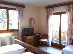 una camera con letto, TV e finestre di Josefinenhof a Neustift im Stubaital