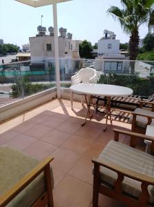 d'une terrasse avec une table et des chaises sur un balcon. dans l'établissement Larnaca, Pervolia 1 bedroom seaside apartment, à Perivólia